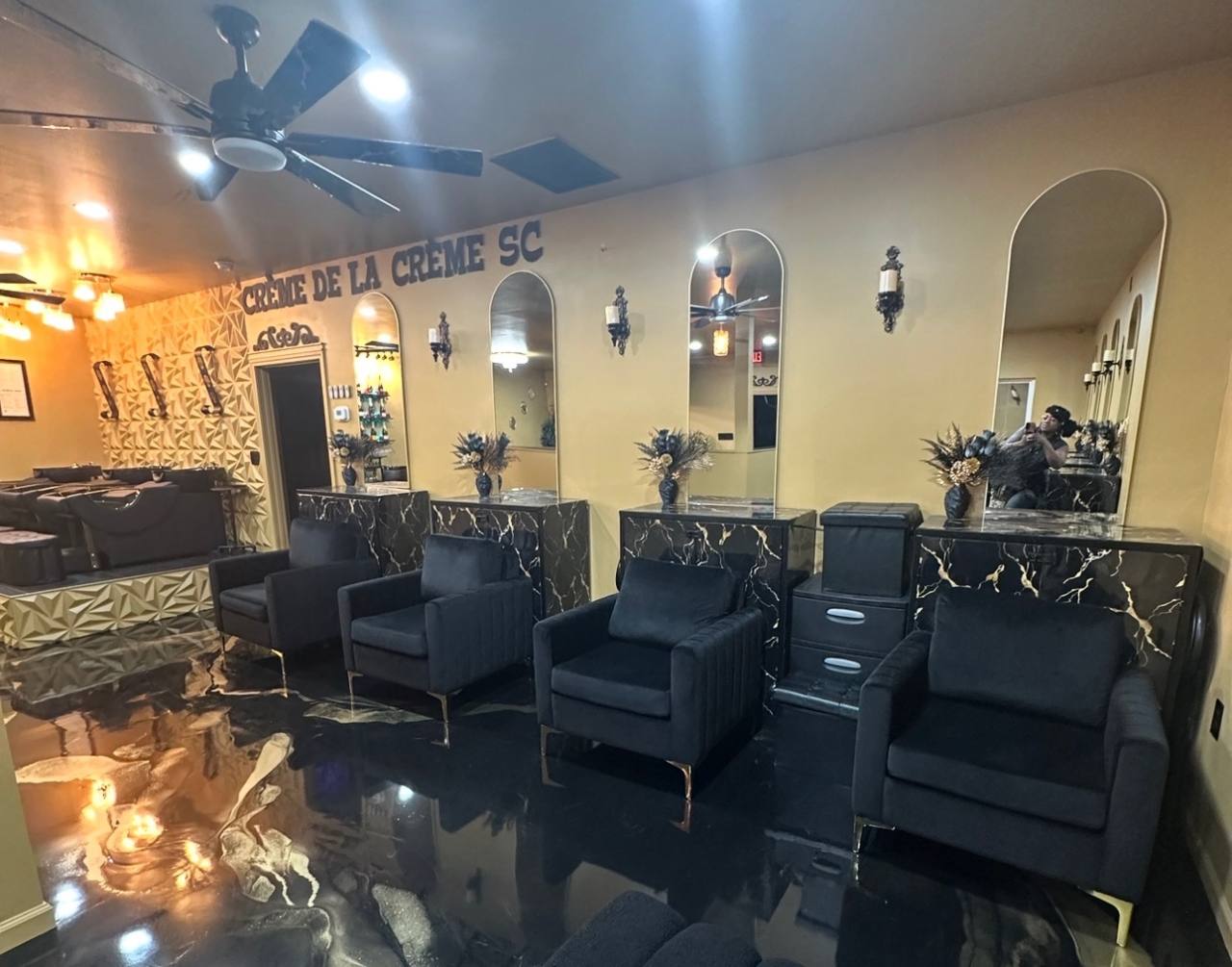 The actual Crème de la Crème salon with black seating, gold walls and arched mirrors